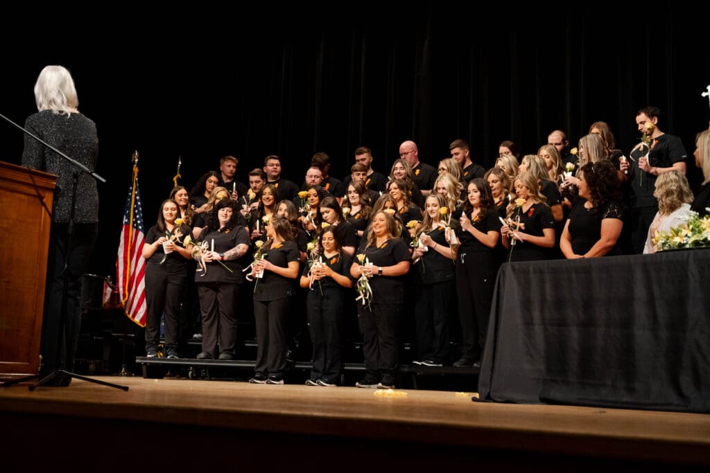 Nursing students standing on the stage for their pinning ceremony