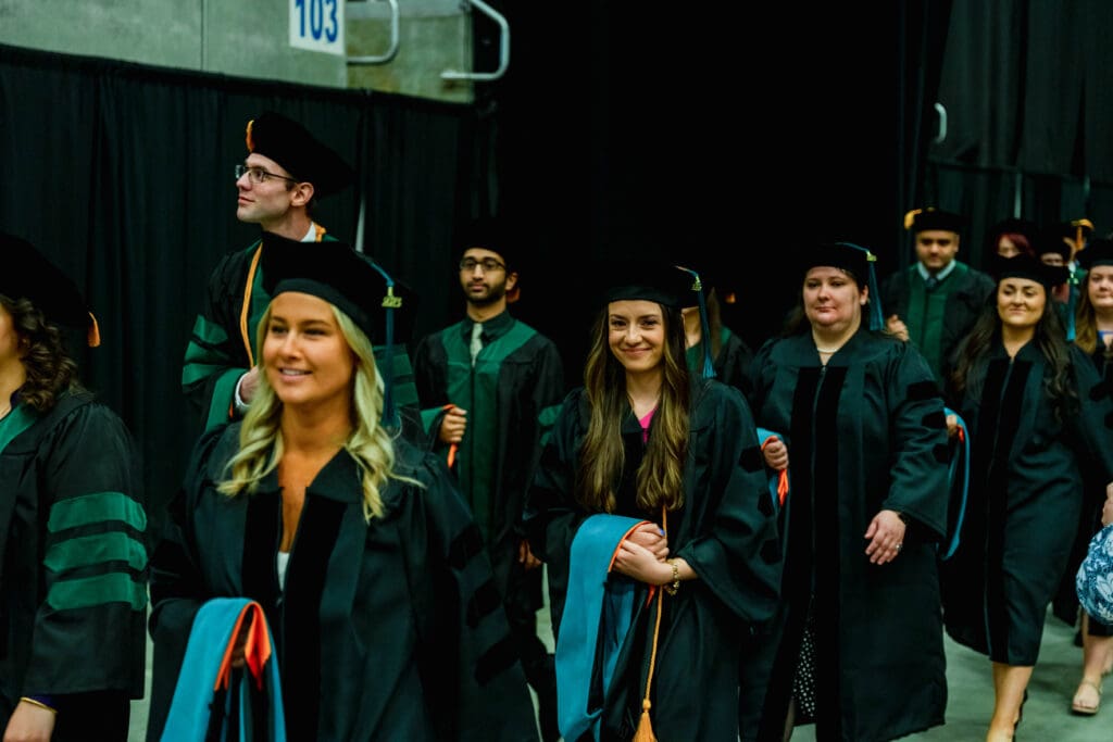 KYCO and KYCOM graduates walking to their seats for commencement