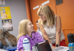 student in education class talks to professor