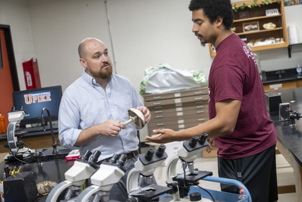 student talking to professor in mushroom lab